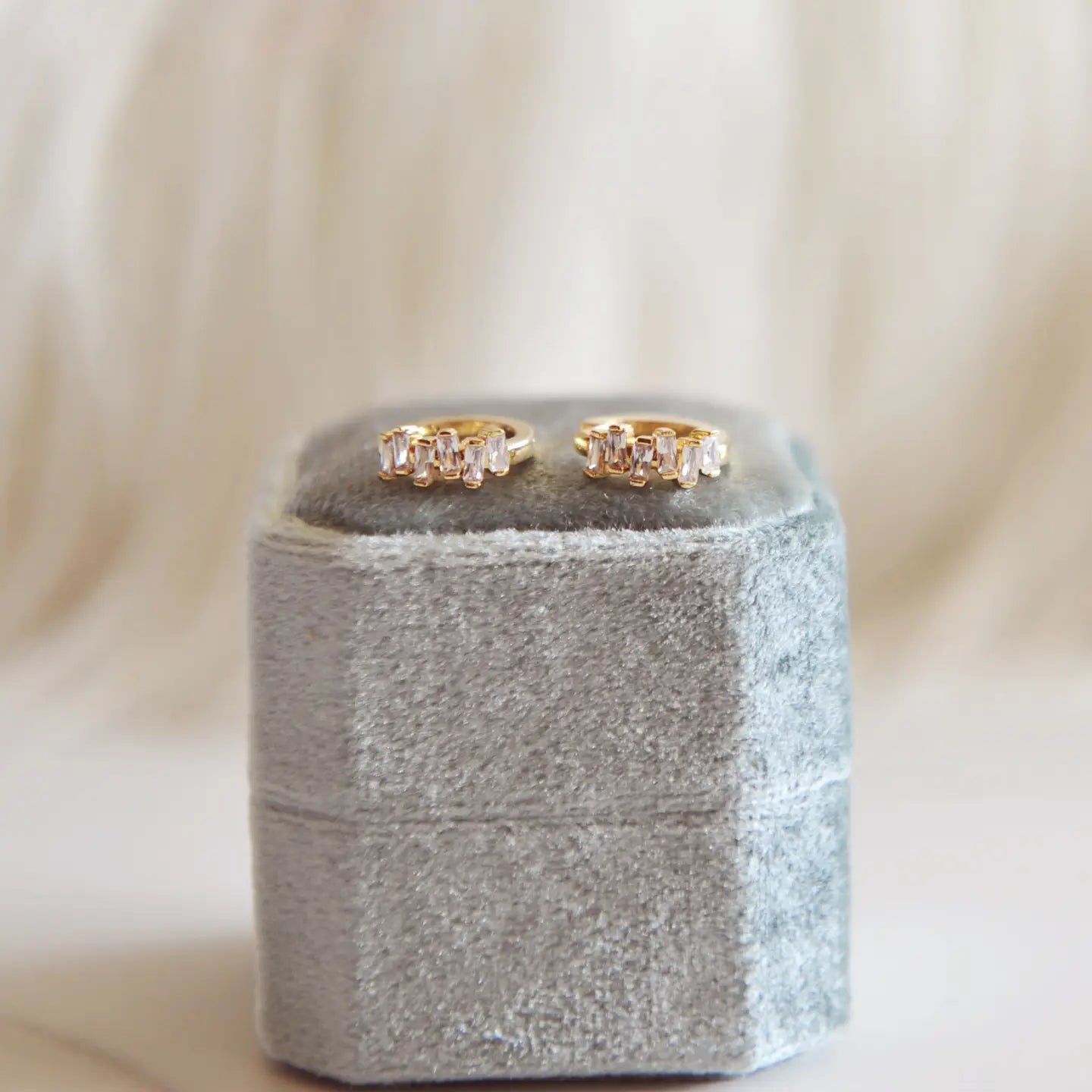 Sunny Huggie Hoops - gold mini hoops on a grey ring box