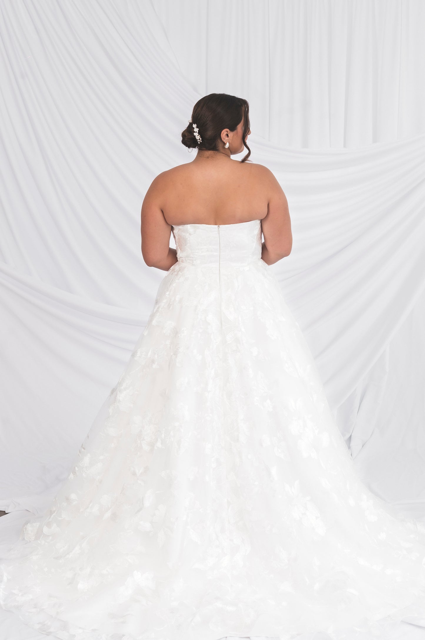 Canadian Made Wedding Dress against a white background draped, stragith across modest backline with a classic lace full skirt
