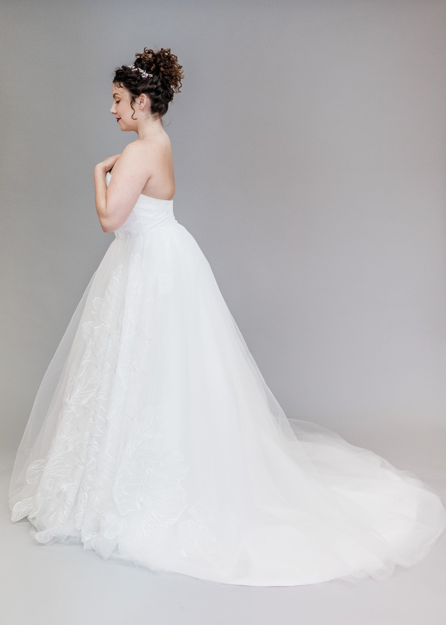 Side view of the white large embroidered tulle ballgown