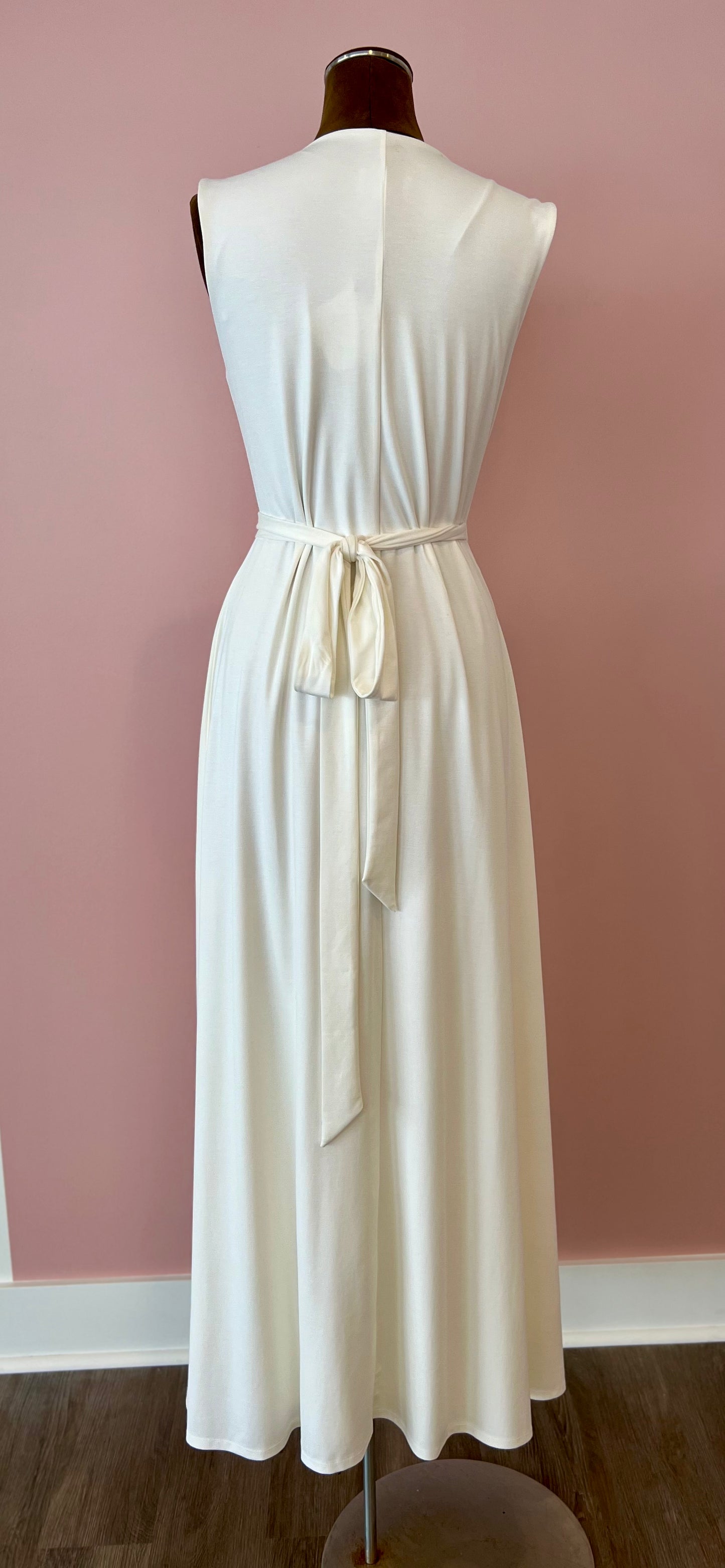 White dress on a mannequin against a pink wall