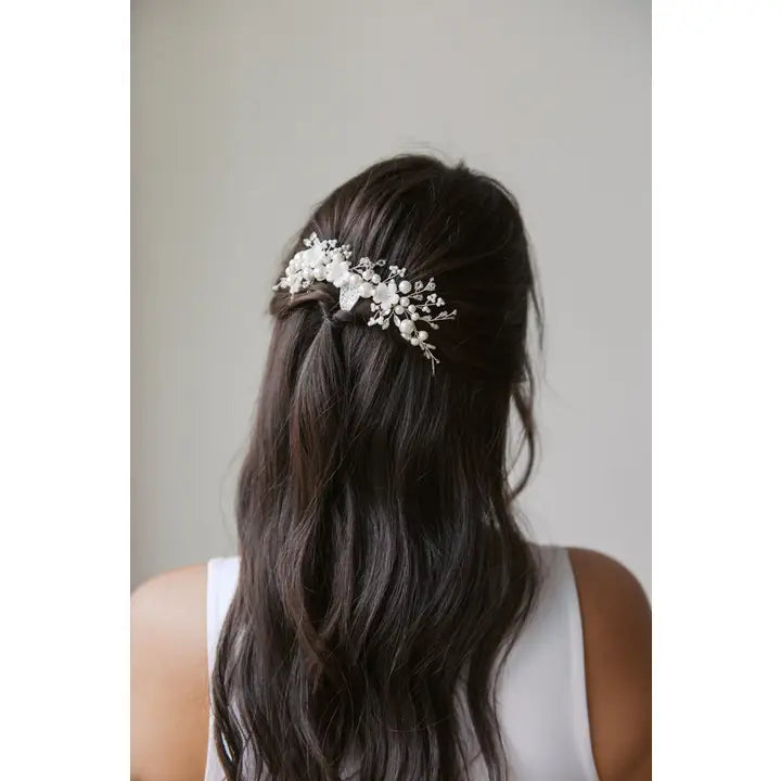 Silver hair comb with beads, pearls and porcelain flowers. In a womans hair