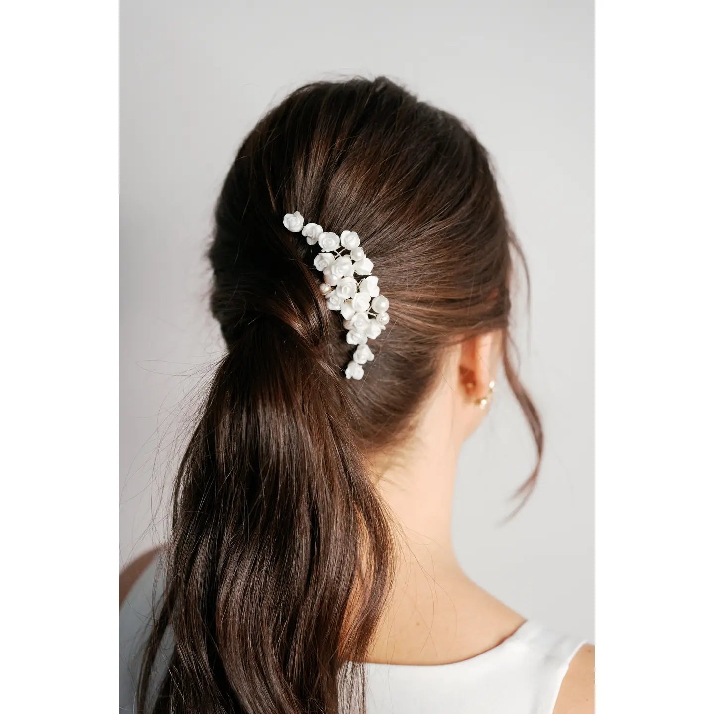 This hair comb adds a little something extra to your wedding hair and style.
Adorned with a bouquet of porcelain little roses land subtle pearls, this hair comb is a simple yet stunning way to complete the finishes touches of your wedding look. 