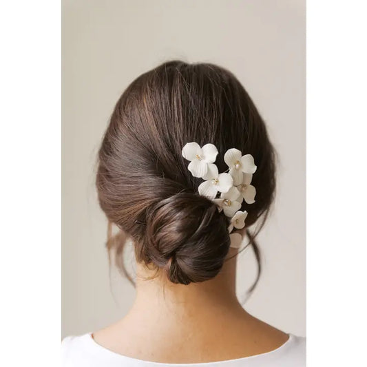 Porcelain flower hair comb in a woman's hair with a low bun