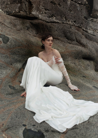 Side view of the Ouma bridal Gown Elysian, showing off the matching gloves that feature lace along the hand edges