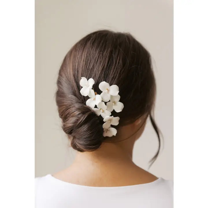 Porcelain flower hair comb in a woman's hair with a low bun