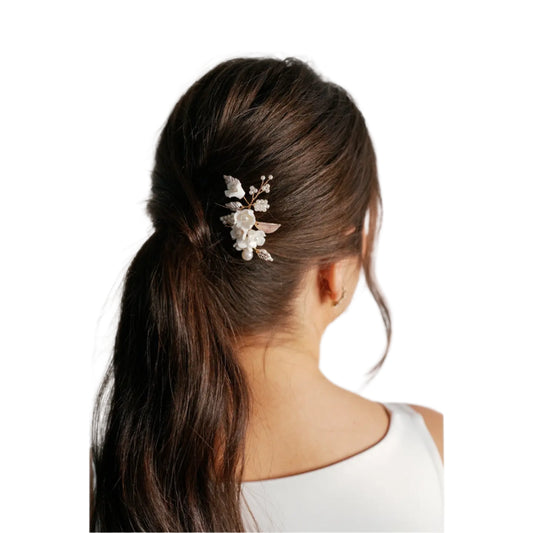 This hair comb adds a little something extra to your wedding look. Adorned with porcelain flowers, pearl beads and rose gold features, this hair comb is simple yet stunning.