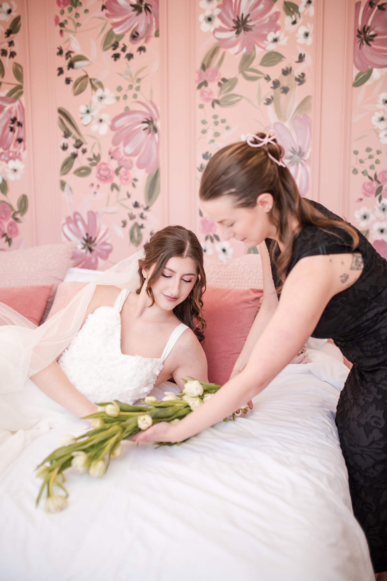 Owner of Ottawa Bridal shop Abby, arranging a beautiful wedding tulip bouquet from Nectar Florals, to the Bride model wearing the Dahlia gown by Kathryn bass with 3d applique and chiffon bows and skirt