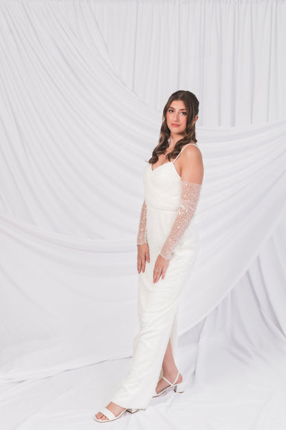 Side view of the Ariel/Tessa column shift wedding dress on a bridal size 10 model with sparkly matching gloves