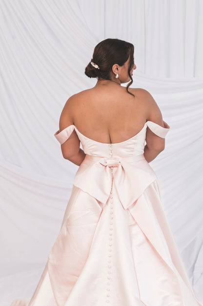 Back View of the scooped backline, oversized bow in satin pink. Plus Size bride in front of Ottawa draped background. 
