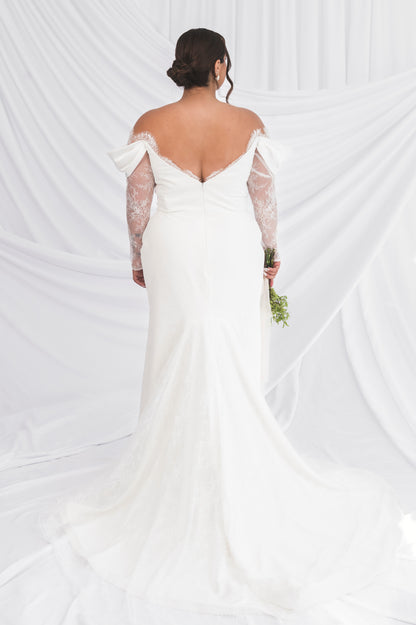 Back of the lace Jane/vicki slong sleeve wedding dress with satin draped sleeves, low back be neck & small godet train against a draped background in Ottawa
