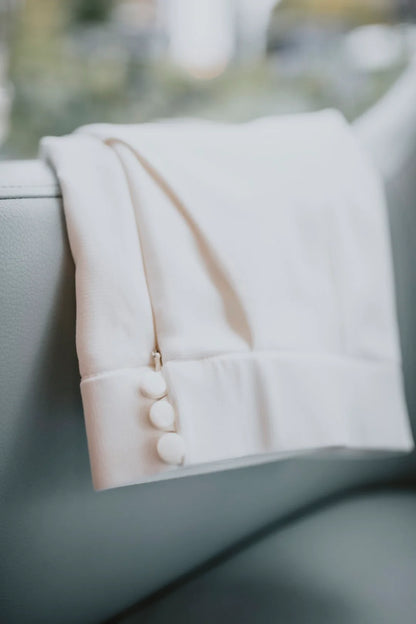 White jac pant outfit with buttons on a blurred background
