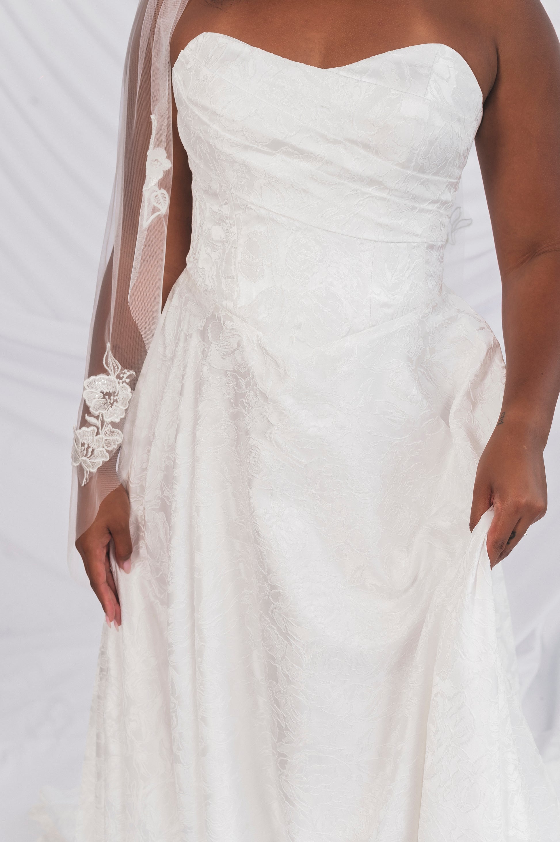 closeup of the jacquared aline basque waist gown with a soft sweetheart neckline and draped bdoice detailng, soft skirt