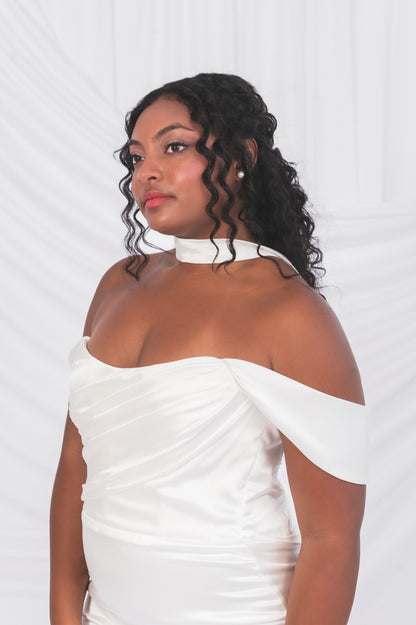 closeup of a black bride with natural hearing wearing a white off-shoulder gown against a white background in Ottawa. Draped bodice and swag sleeves, satin simple bridal scarf 