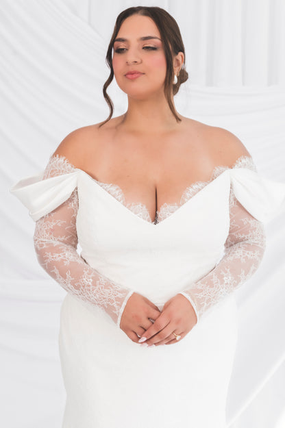 Closeup of the bodice of the Jane/Vicki with a swag italian sleeve over a lace long sleeve. Fitted bottom behind a draped background in Ottawa