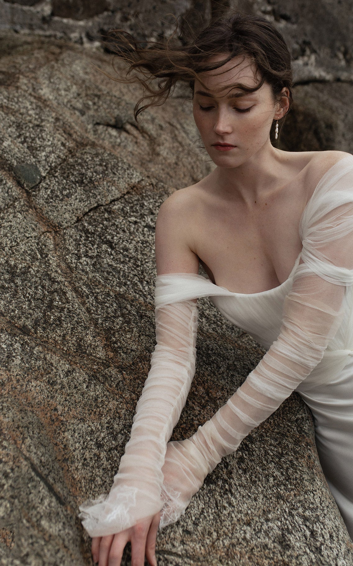  These gloves feature exquisite French chantilly lace gathered at the fingertips. Measuring approximately 20 inches long, they offer a touch of sophisticated grace that complements the contemporary bridal attire OUMA is known fo