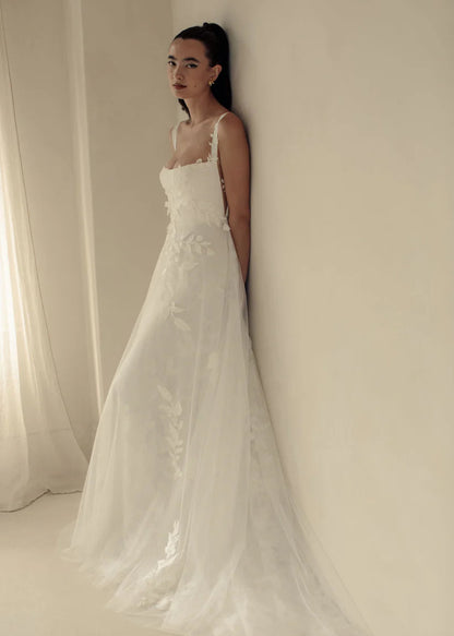 Gia, a flowy A-line gown with asymmetrical lace placement and squared neckline.&nbsp; A structured bodice with grosgrain straps features mesh paneling to enhance shape and style.