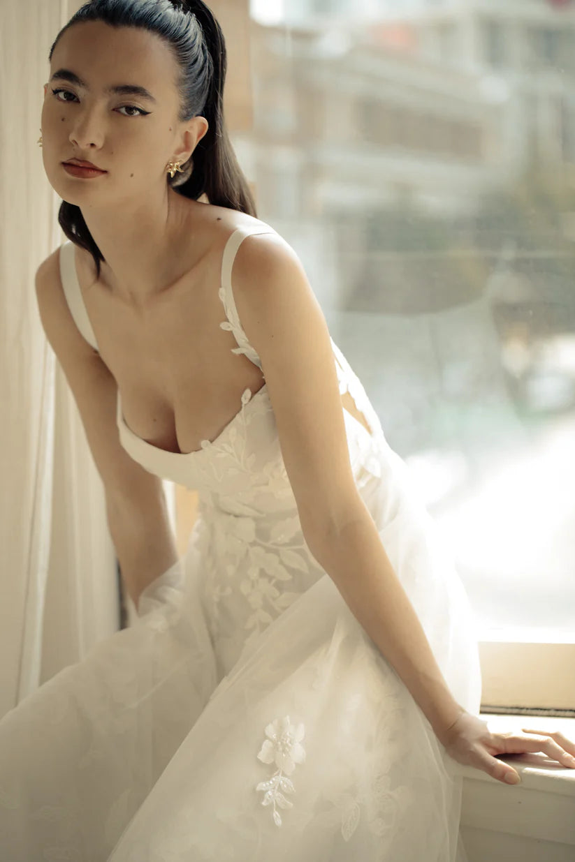 Gia, a flowy A-line gown with asymmetrical lace placement and squared neckline.&nbsp; A structured bodice with grosgrain straps features mesh paneling to enhance shape and style.