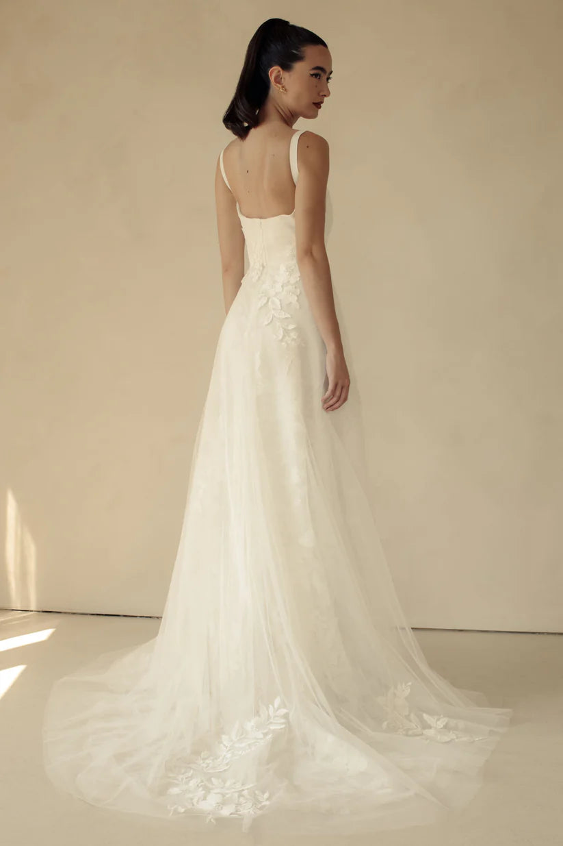 Gia, a flowy A-line gown with asymmetrical lace placement and squared neckline.&nbsp; A structured bodice with grosgrain straps features mesh paneling to enhance shape and style.