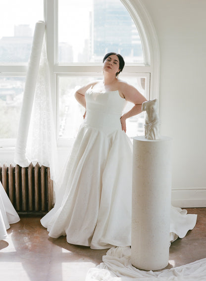 Plus size bride showing off the Lauralie in a fitted bodice with a drop waist skirt, different shaped