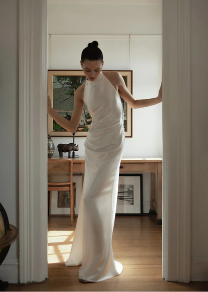 Laurene is a simple and sexy silk dress with halter neck. Adorned with pleats in the front, a leg slit and jaw dropping open back design. A detachable bow in the back finished off this timeless gown.