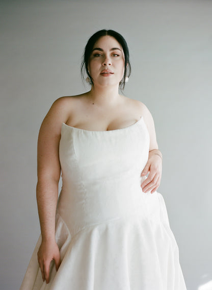 A close up view of the Lauralie in the ivory cotton burnout fabric, plus size model with dropped matching earrings