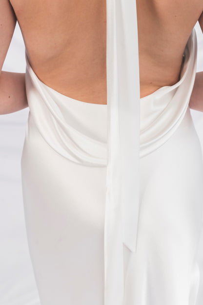 Closeup of the satin back, extremely low back wedding dress with a draped neck