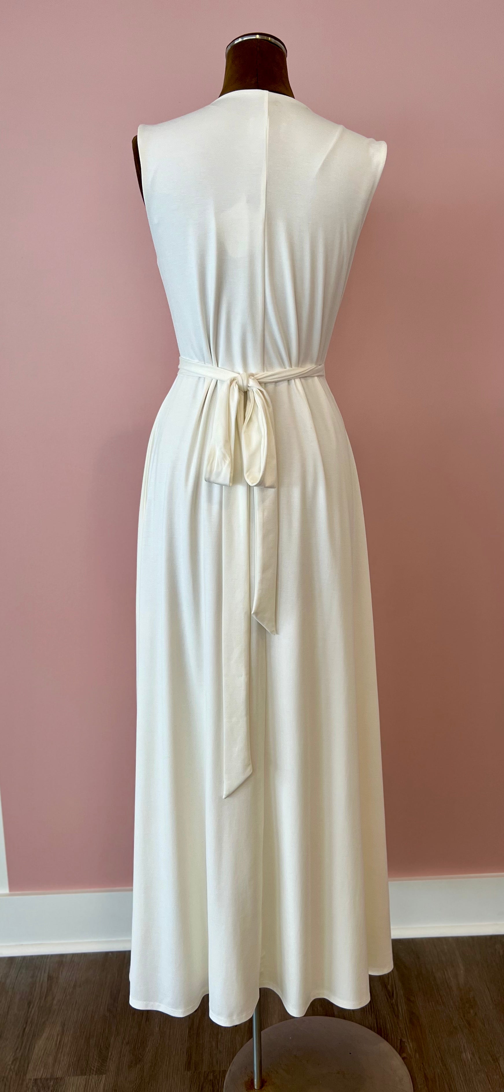 White dress on a mannequin against a pink wall