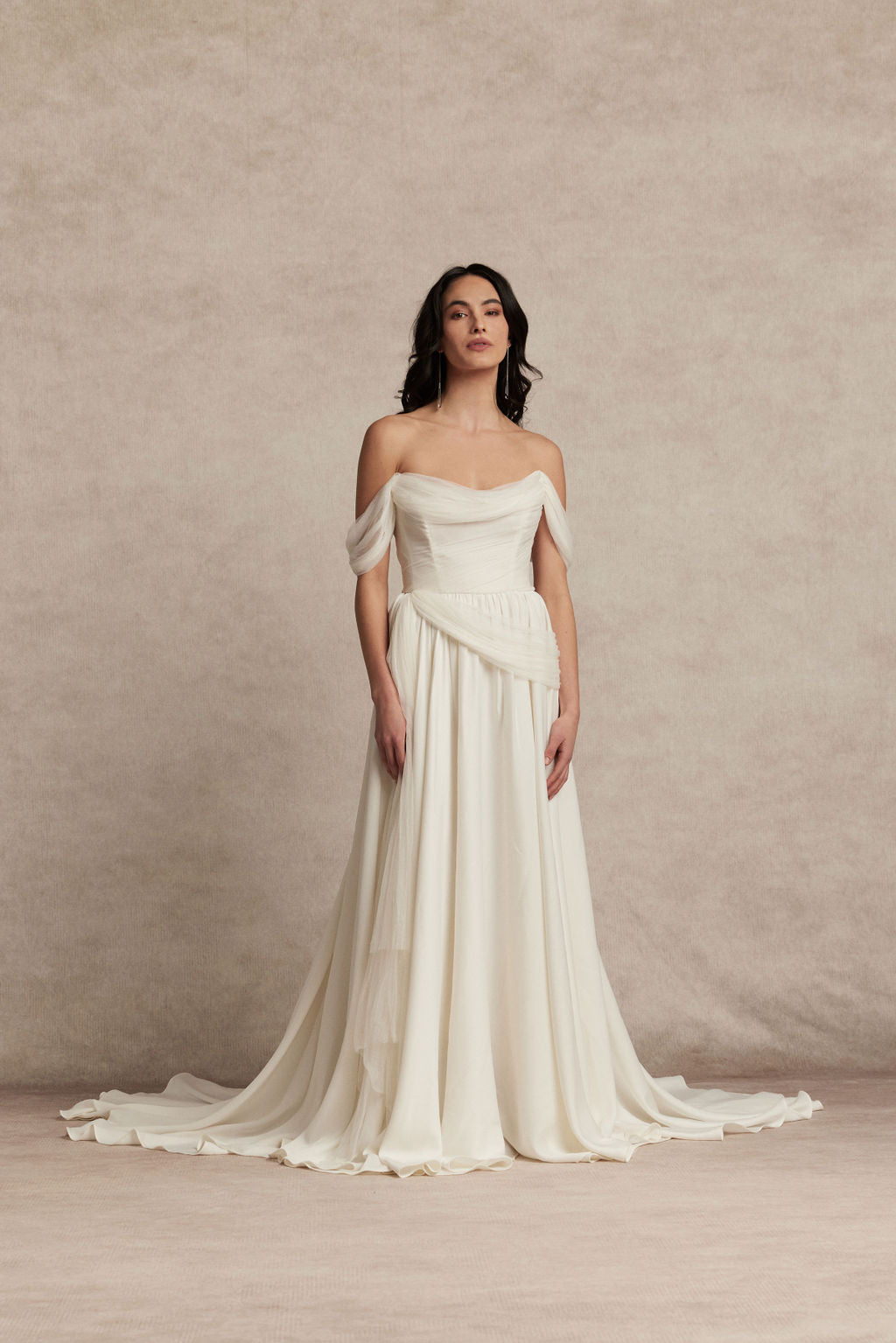Woman wearing a white off-shoulder gown against a beige background. Sora by Ouma
