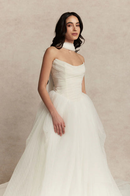 Meet Zara, a pleated tulle romantic ball gown with draped bodice, basque waist and voluminous skirt. Pair her with a gorgeous silk scarf to finish this unique beauty.