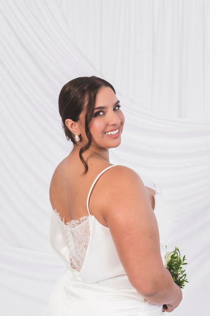 Side view of the Ariel/Tessa wedding dress with delicate lace on the back with matching satin buttons and draped satin bodice