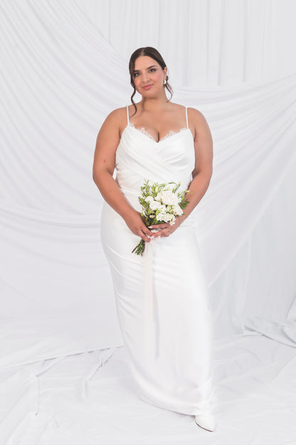 Plus Size Weding Dress Satin Column Italian Satin Dress with V neck, peakaboo lace and a narrow strap against and draped white background