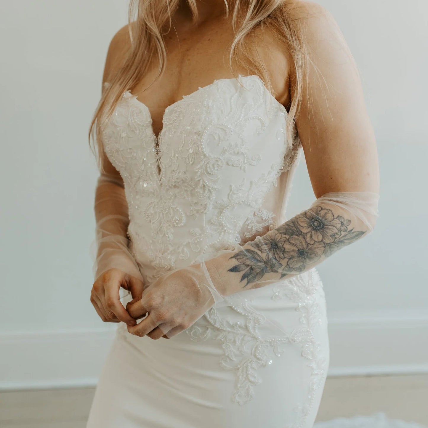 Model wearing a wedding dress and plain tulle sleeves