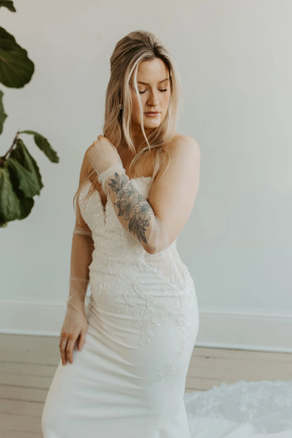 Model wearing a wedding dress and plain tulle sleeves