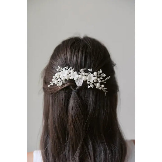 Silver hair comb with beads, pearls and porcelain flowers. In a womans hair
