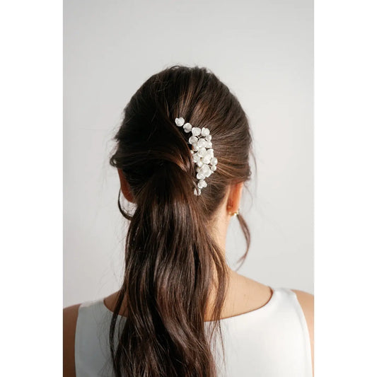 This hair comb adds a little something extra to your wedding hair and style.

Adorned with a bouquet of porcelain little roses land subtle pearls, this hair comb is a simple yet stunning way to complete the finishes touches of your wedding look.&nbsp;