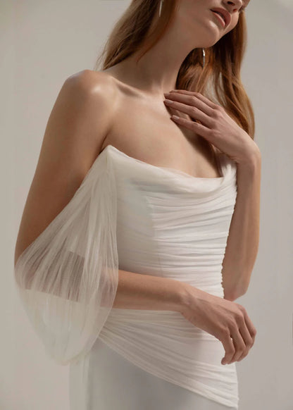 This fit and flare triacetate gown stuns with a luxurious silk tulle overlay, and asymmetrical shoulder detail.