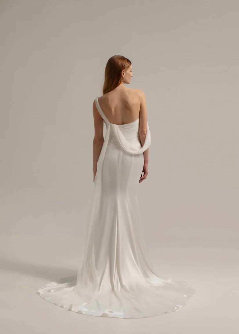 This fit and flare triacetate gown stuns with a luxurious silk tulle overlay, and asymmetrical shoulder detail.