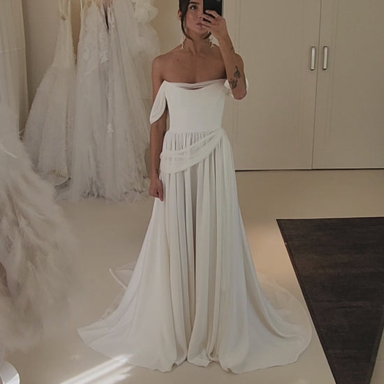 Model wearing the sora Aline gown from ouma. Soft scoop neckline, silk tulle draped features and removable sleevees 