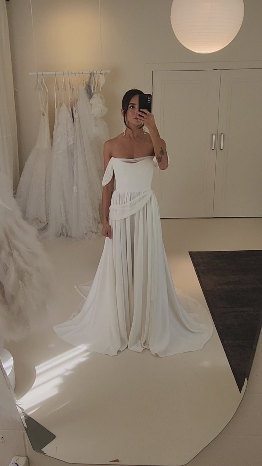 Model wearing the sora Aline gown from ouma. Soft scoop neckline, silk tulle draped features and removable sleevees 