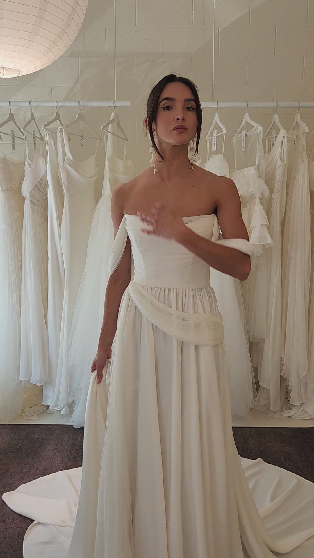 Model wearing the sora Aline gown from ouma. Soft scoop neckline, silk tulle draped features and removable sleevees 