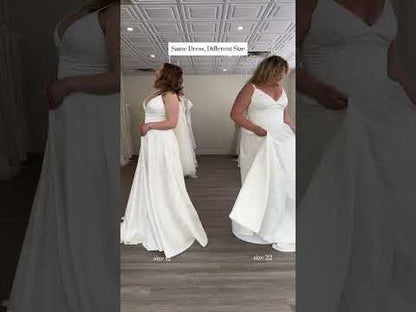 Showing off two sizes of the same dress, a size 12 and a size 22. a textured simple Aline gown featuring a narrow strap, v neck bodice, and lighweight, but full aline skirt.