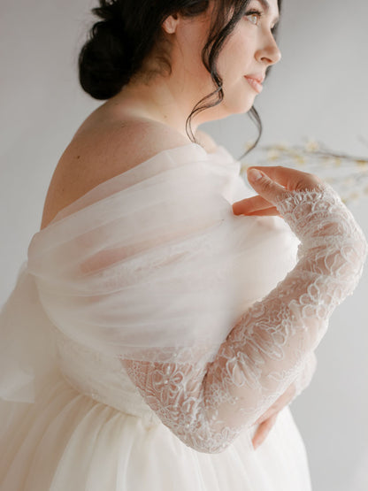 Woman wearing a white lace wedding dress with a soft background